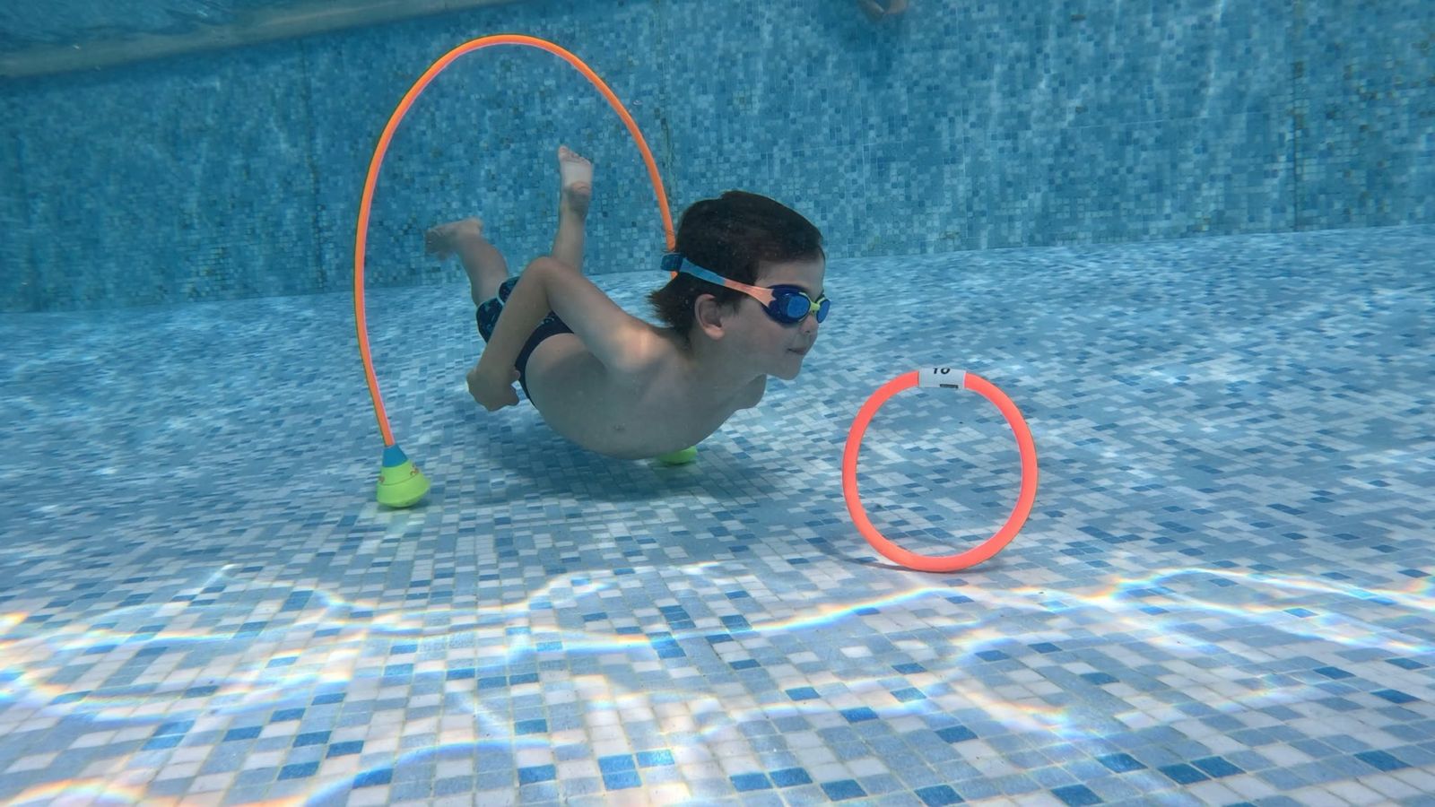 Enfant nageant sous l'eau pendant un cours de natation