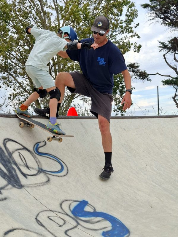Le moniteur guide un jeune skateur au bord de la rampe