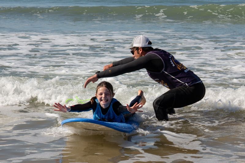 Élève et moniteur dans les vagues de la Pège